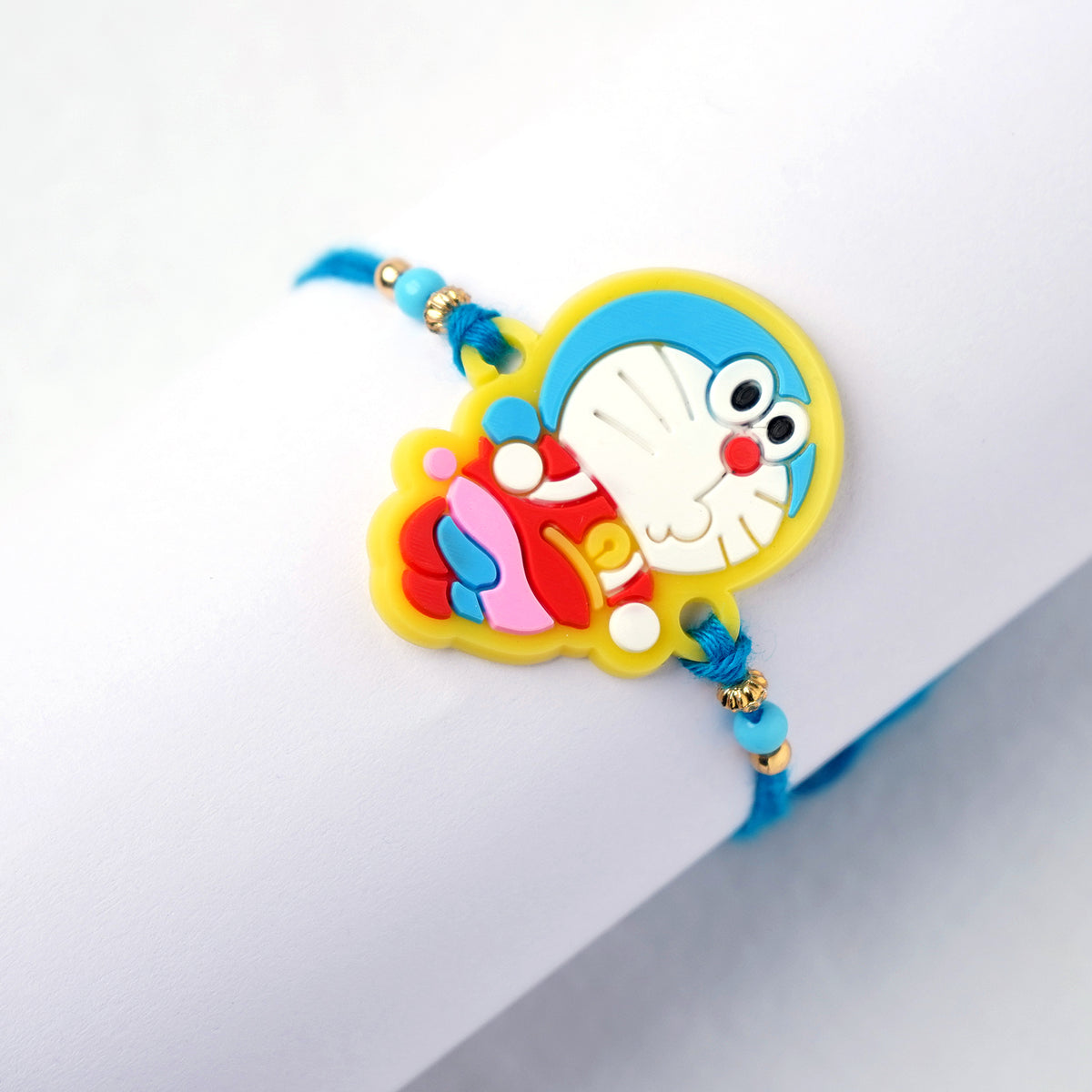 Cute Doraemon Character Kids Rakhi with Soft Blue Thread & Golden Beads